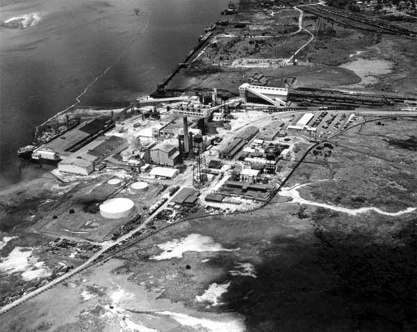 Aerial photograph of the pulp mill on the Amelia River at Fernandina Beach, with the deep-water dock, storage tanks and rail sidings laid out along the marsh