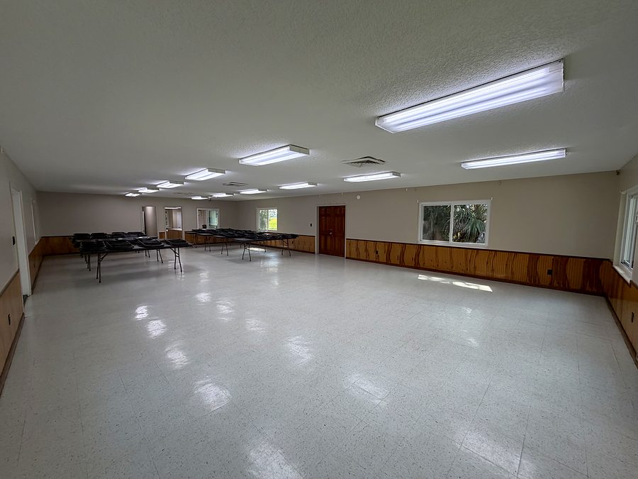 The main hall from the entry end, showing the open floor, wood wainscoting and windows
