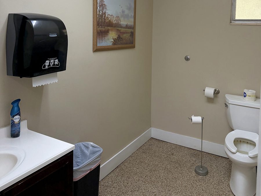 One of the club restrooms, showing the vanity and sink, paper towel dispenser and toilet