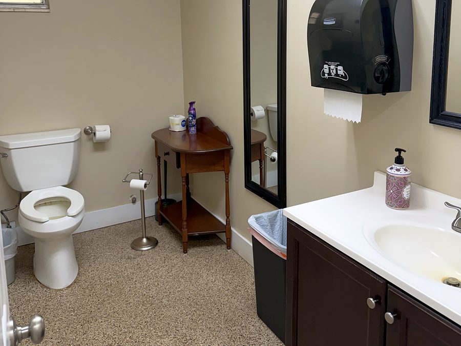 The second club restroom, showing the toilet, mirror and vanity with sink
